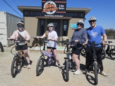 Man, woman, 2 children on bikes.